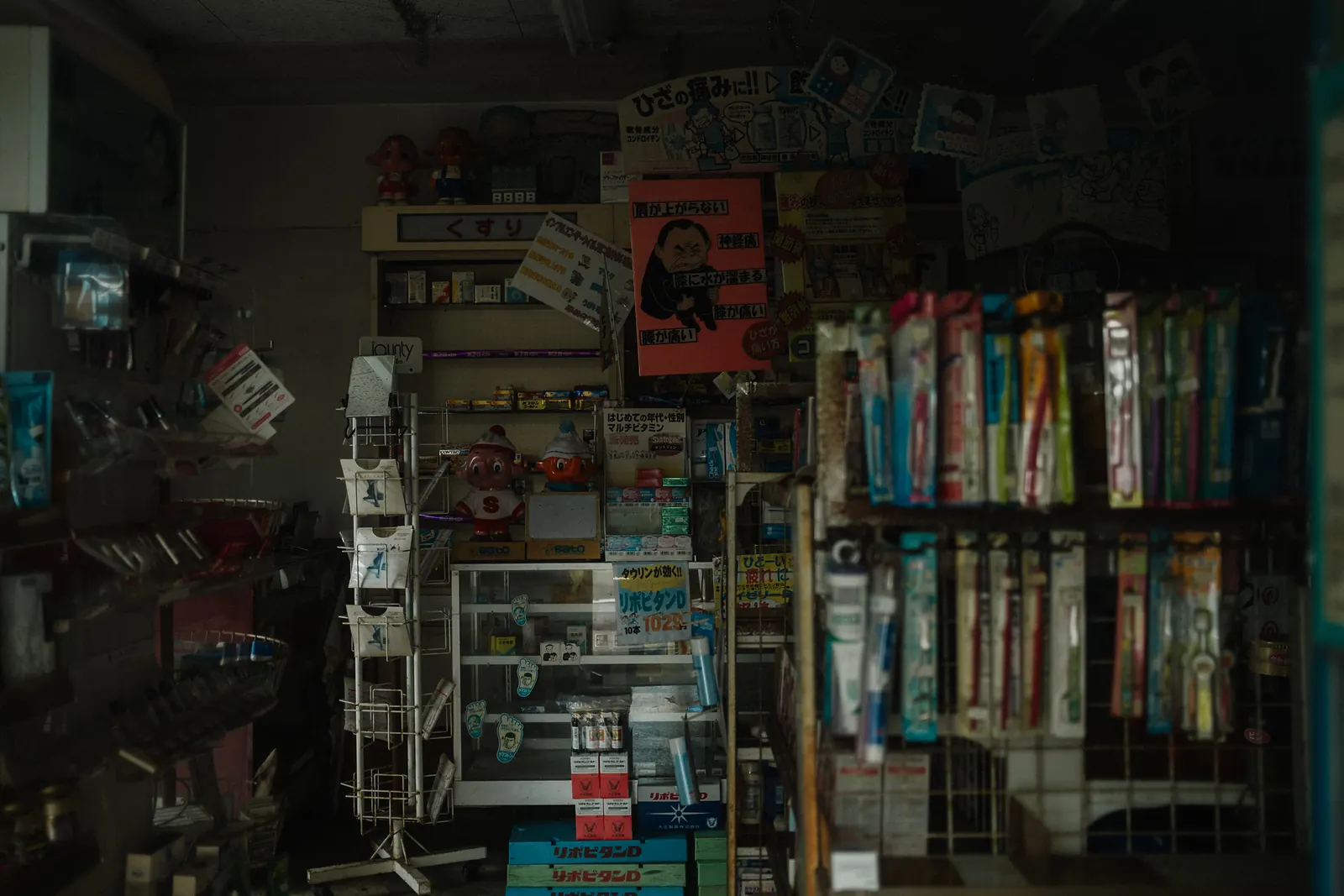 The crowded shelves of a small island drugstore, toothbrushes, medicine and old posters.